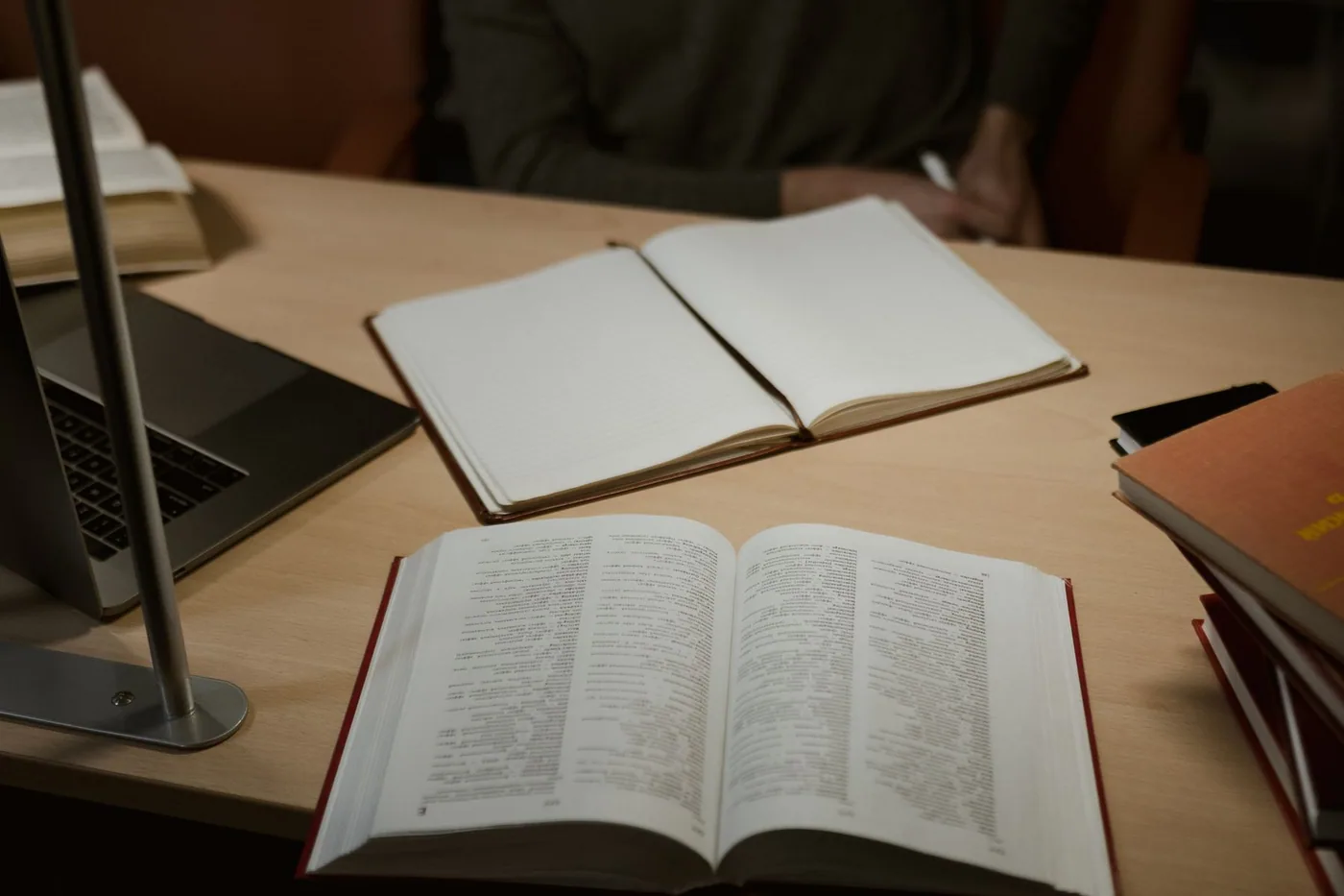 Mesa con libros, ordenador y cuaderno